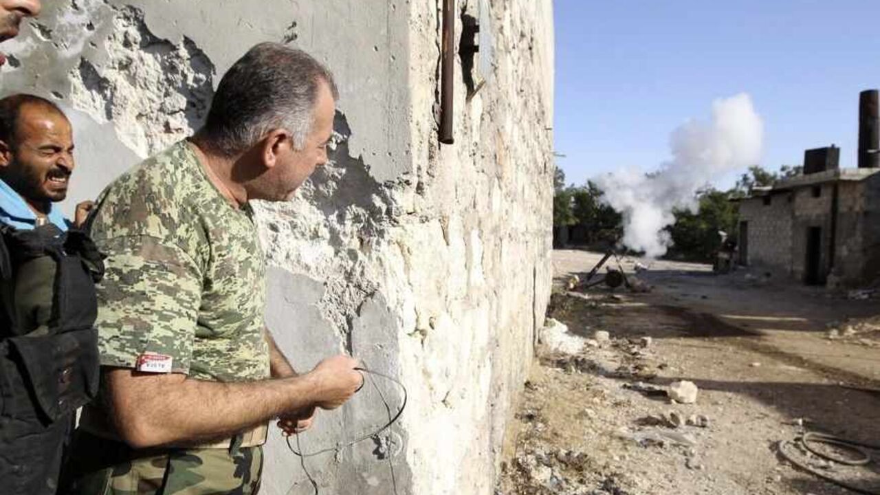SYRIA-CRISIS/ Colonel Abdul-Jabbar al-Aqidi, commander of the rebels’ Military Council in Aleppo, launches a mortar shell at the frontline in the Al-Sakhour neighborhood of Aleppo, June 21, 2013. REUTERS/Muzaffar Salman (SYRIA - Tags: POLITICS CIVIL UNREST) - RTX10WGT