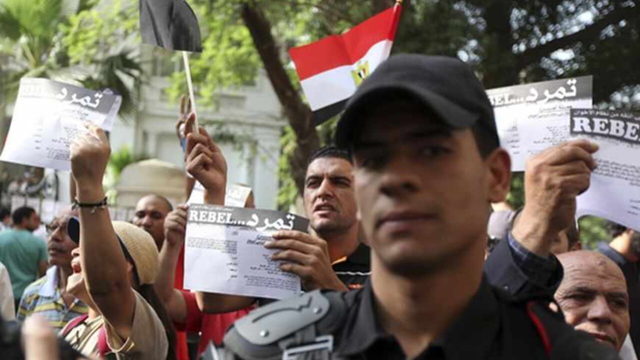 EGYPT/ Anti-Mursi protesters, made up of intellectuals and artists, hold up signs reading: "rebel", in front of the Ministry of Culture during a demonstration against what they claimed are increasing influence of the Muslim Brotherhood over the Ministry of Culture and Minister of Culture Alaa Abdel Aziz, in Cairo June 11, 2013. Egyptian President Mohamed Mursi increased the influence of his Muslim Brotherhood over government in a cabinet reshuffle in May that replaced two ministers involved in crucial talks with t