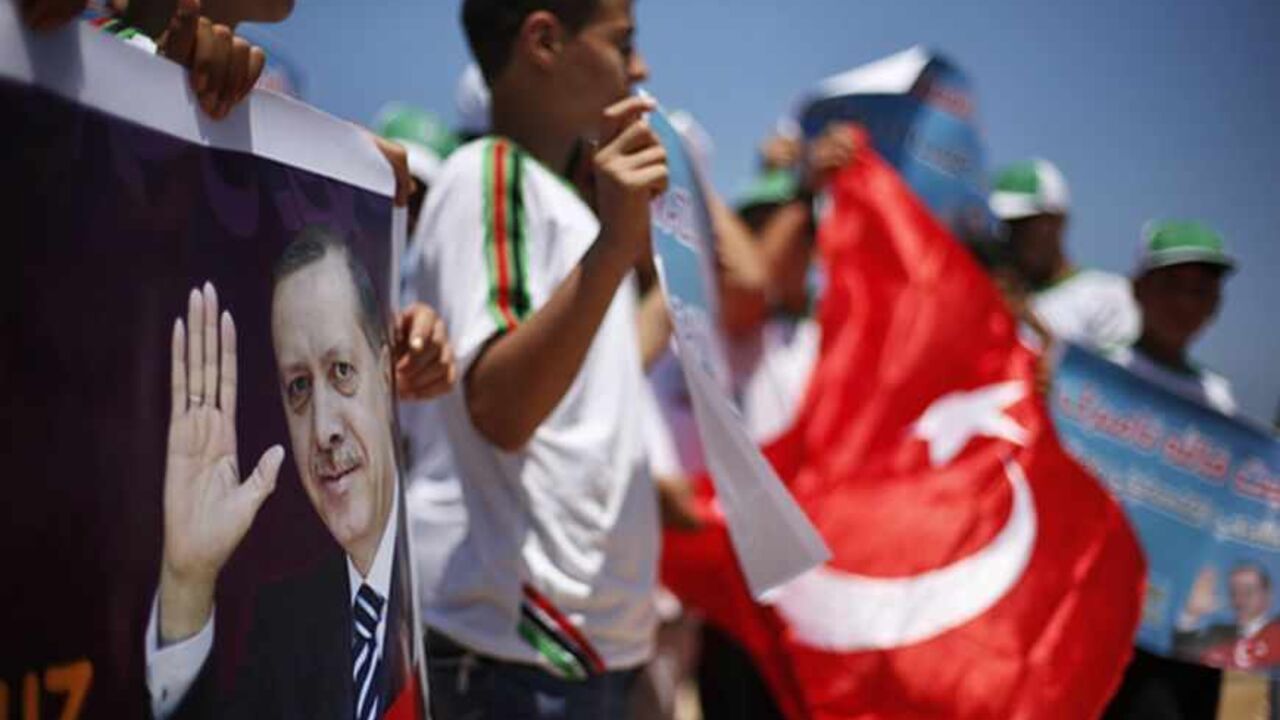 PALESTINIANS-TURKEY/ Palestinian youths take part during a rally in support of Turkish Prime Minister Recep Tayyip Erdogan (seen on banner), at the Seaport of Gaza City June 18, 2013. REUTERS/Suhaib Salem (GAZA - Tags: POLITICS CIVIL UNREST) - RTX10RQC