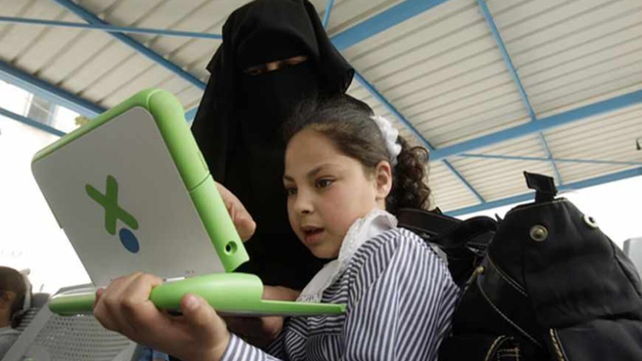 PALESTINIANS/ A teacher shows a Palestinian schoolgirl how to use a new laptop at a United Nations school in Rafah refugee camp in the southern Gaza Strip April 29, 2010. The United Nations Relief and Works Agency (UNRWA) launched a campaign to distribute some 200,000 laptops to UNRWA students in the Gaza Strip, an UNRWA official said. REUTERS/Ibraheem Abu Mustafa (GAZA - Tags: POLITICS EDUCATION) - RTR2D9BN