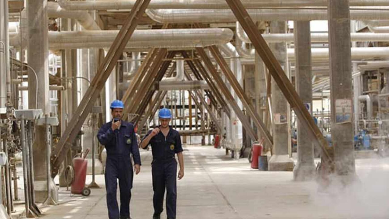 Iraqi workers walk through the al-Doura refinery in Baghdad April 9, 2012. OPEC is seeking a balance in world oil prices, but political instability rather than production issues are affecting the market price, Iraqi Oil Minister Abdul Kareem Luaibi said on Monday.  REUTERS/Mohammed Ameen (IRAQ - Tags: ENERGY POLITICS) - RTR30IVL