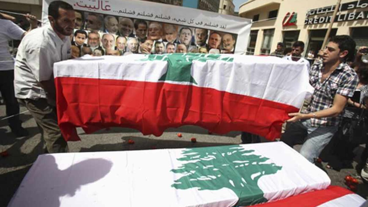 LEBANON-PARLIAMENT/ELECTION Protesters carry mock coffins draped with Lebanon's national flags, representing the parliament, as they express their refusal of the extension of parliamentary terms near the parliament in Beirut May 31, 2013. Lebanese lawmakers agreed on Friday to postpone a June parliamentary election until late next year due to instability in neighbouring Syria and political deadlock at home. Words on the banner read, "You failed in everything. You failed, you failed, you failed... Go home!" REUTERS/Sharif Karim (LEB