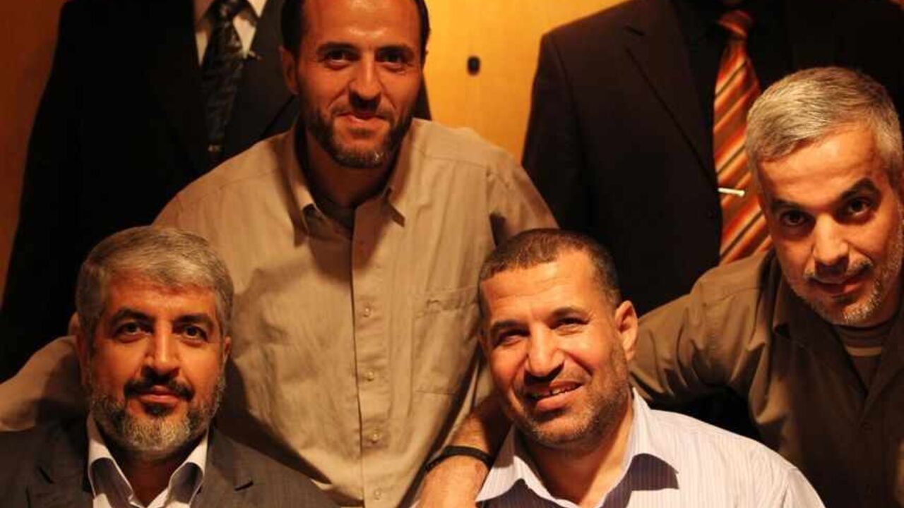 PALESTINIANS-ISRAEL/PRISONERS Hamas leader Khaled Meshaal (L) poses for photograph with Ahmed Al-Jabari (R), top commander of Hamas armed wing Al-Qassam brigades, and Palestinian prisoners (back) freed in a prisoner swap deal between Hamas and Israel, in Cairo October 18, 2011. Israeli soldier Gilad Shalit and hundreds of Palestinians crossed Israel's borders in opposite directions on Tuesday as a thousand-for-one prisoner exchange brought joy to families but did little to ease decades of conflict. REUTERS/Hamas Office/Handout (EGYPT -