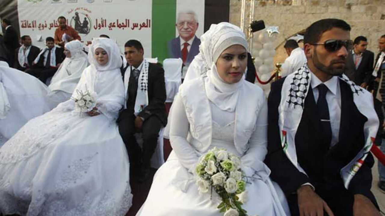PALESTINIANS/ Palestinian couples participate in a mass wedding in the West Bank city of Nablus May 12, 2011. A group of 22 couples, some disabled, participated in the wedding ceremony which was sponsored by the United Arab Emirates. REUTERS/Abed Omar Qusini (WEST BANK - Tags: SOCIETY) - RTR2MBU0