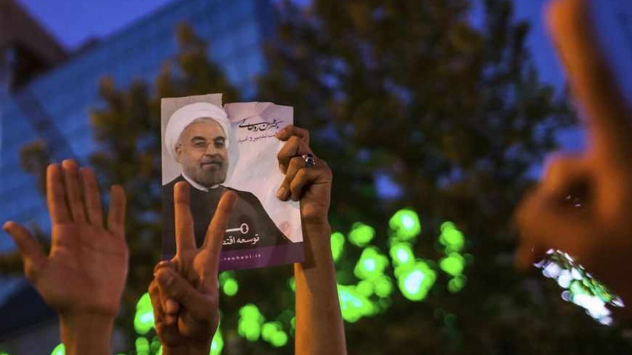 IRAN-ELECTION/ Supporters of moderate cleric Hassan Rohani hold a picture of him as they celebrate his victory in Iran's presidential election on a pedestrian bridge in Tehran June 15, 2013. Rohani won Iran's presidential election on Saturday, the interior ministry said, scoring a surprising landslide victory over conservative hardliners without the need for a second round run-off. REUTERS/Fars News/Sina Shiri (IRAN - Tags: POLITICS ELECTIONS) ATTENTION EDITORS - THIS IMAGE WAS PROVIDED BY A THIRD PARTY. FOR EDITORIAL U