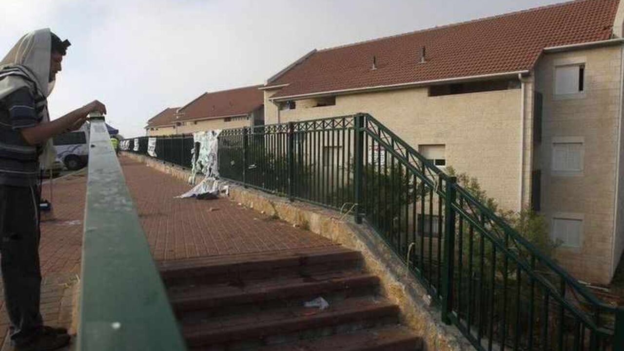 Jewish settler recites morning prayers at Ulpana neighbourhood of Beit El settlement A Jewish settler recites morning prayers before some families began moving out of the Ulpana neighbourhood of the Beit El settlement near the West Bank city of Ramallah June 26, 2012. Settlers on Tuesday began moving out of apartment blocs that Israel's Supreme Court ruled had been built illegally on Palestinian-owned land, after reaching an agreement with the government to go quietly. REUTERS/Baz Ratner (WEST BANK - Tags: POLITICS RELIGION TPX IMAGES OF THE DAY) - RTR34608