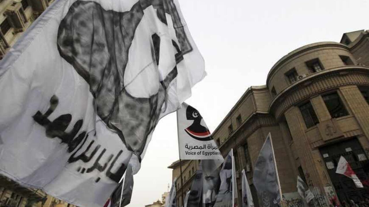 Protesters against Egyptian President Mohamed Mursi and members of the Muslim Brotherhood hold flags during a protest rally in Cairo Protesters against Egyptian President Mohamed Mursi and members of the Muslim Brotherhood hold flags during a protest rally in front of the courthouse and the Attorney General's office, near Tahrir Square in Cairo March 8, 2013. International Women's Day falls on March 8. The flag (L) reads, "Sabrin Mohamed", a woman who died during the Egypt uprising. REUTERS/Amr Abdallah Dalsh (EGYPT - Tags: POLITICS CIVIL UNREST) - RTR3EQS7