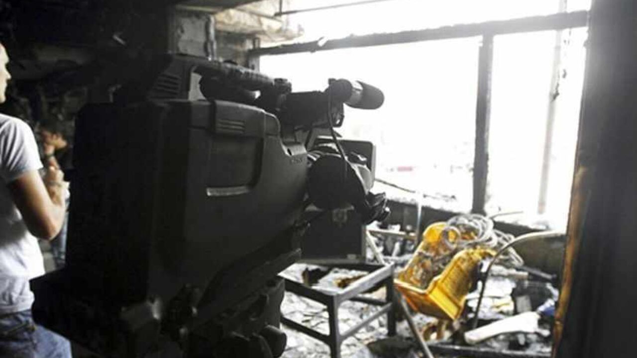 EGYPT-VIOLENCE/ People are seen in a burnt studio of Al Jazeera TV network, at Tahrir Square in Cairo November 21, 2012. The studio used by the Al Jazeera TV network was set on fire on Wednesday in central Cairo as security forces and protesters fought in the streets of the Egyptian capital for a third day. REUTERS/Mohamed Abd El Ghany (EGYPT - Tags: POLITICS CIVIL UNREST MEDIA) - RTR3APPP