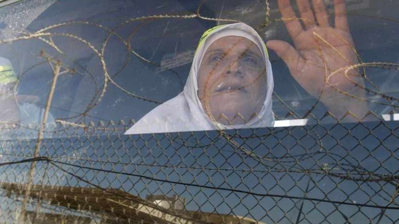 A Palestinian woman waves her hand as she sits in a bus before leaving Rafah border crossing in the southern Gaza Strip A Palestinian woman waves her hand as she sits in a bus before leaving Rafah border crossing for the annual haj pilgrimage in Mecca, in the southern Gaza Strip October 14, 2011. REUTERS/Mohammed Salem (GAZA - Tags: POLITICS RELIGION TPX IMAGES OF THE DAY) - RTR2SO7F