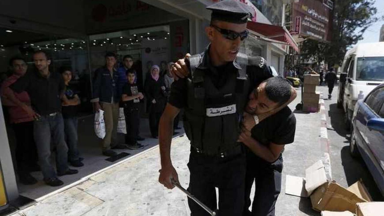 A Palestinian policeman detains protester during demonstration against renewal of stalled peace talks with Israel, in Ramallah A Palestinian policeman detains a protester during a demonstration against the renewal of stalled peace talks with Israel, in the West Bank city of Ramallah, July 28, 2013. Israel was expected on Sunday to approve releasing more than 100 Arab prisoners as a step to renew stalled peace talks with the Palestinians ahead of plans to convene negotiators in Washington later this week. REUTERS/Mohamad Torokman (WEST BANK - Tags: POLITICS CIVIL UNREST) - RTX122FX