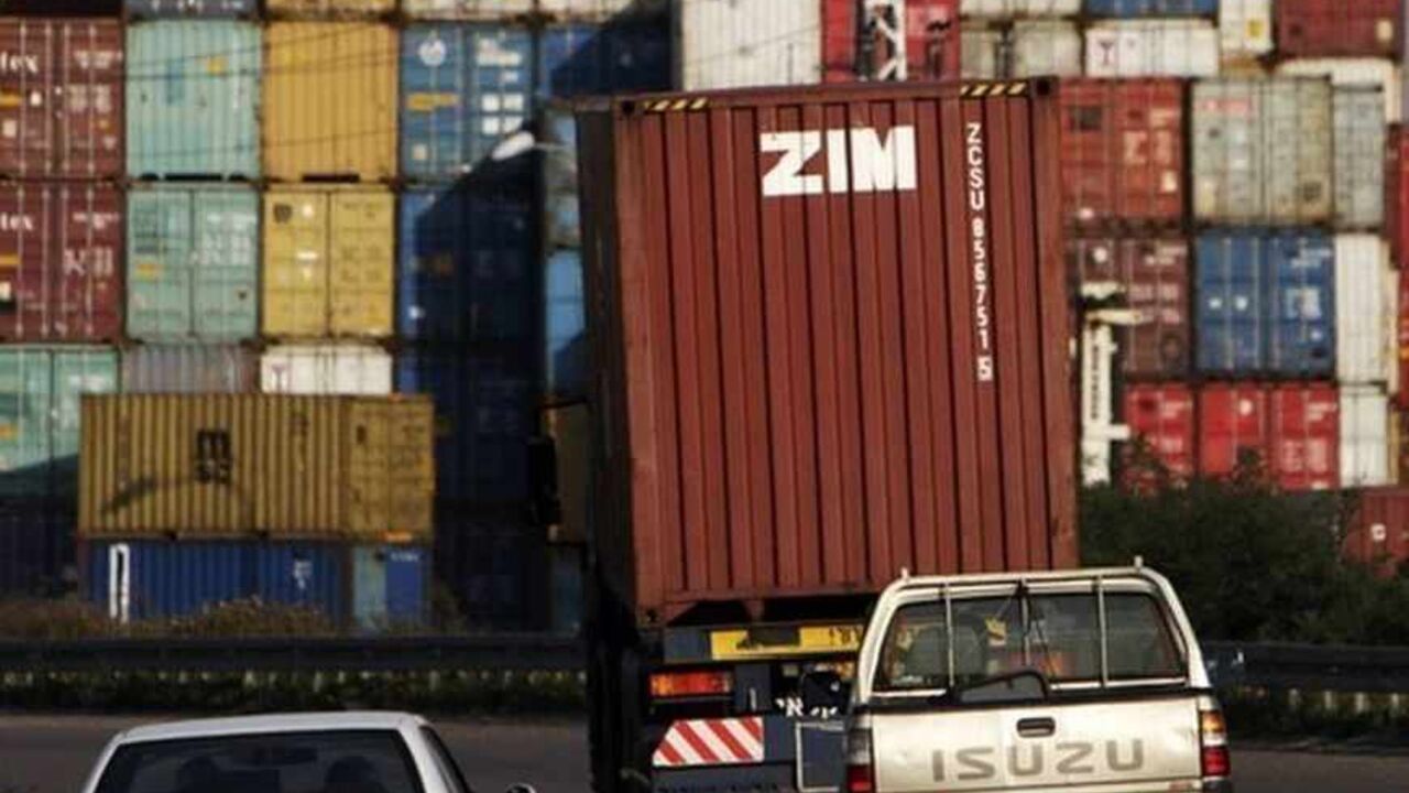 Cars drive behind a truck transporting a Zim container just outside Israel's port of Ashdod Cars drive behind a truck transporting a Zim container just outside Israel's port of Ashdod February 23, 2012. Zim, Israel's biggest shipping company, had to reach a debt settlement with its bond holders after they were hit by a downturn in the global shipping industry. Greek debt may be making headlines globally, but in Israel a trend of corporate debt settlements are making the front page. REUTERS/Amir Cohen (ISRAEL - Tags: BUSINESS) - RTR2YB9Y