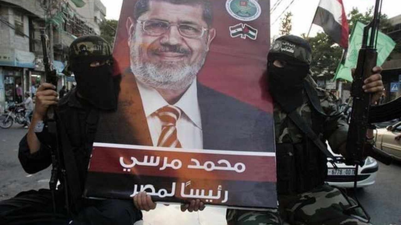 Hamas militants hold a poster depicting Morsy of the Muslim Brotherhood as they celebrate in Gaza City after he was declared Egypt's president Hamas militants hold a poster depicting Mohamed Morsy of the Muslim Brotherhood as they celebrate in the street in Gaza City after he was declared Egypt's first democratic president June 24, 2012. Morsy's win was hailed by Hamas, the Islamist group governing Gaza and which is locked in a power-struggle with the West Bank-based, U.S.-backed Palestinian Authority of President Mahmoud Abbas. REUTERS/Mohammed Salem (GAZA - Tags: POLITICS ELECTIONS TPX IMAGES OF THE DAY MILITARY) - RTR343IV