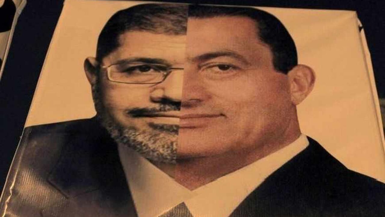 An Egyptian holds a banner against President Mohammed Morsi, comparing him with Hosni Mubarak, in Cairo An Egyptian holds a banner against President Mohammed Morsi, comparing him with Hosni Mubarak, in Cairo October 19, 2012. Hundreds of Egyptian liberals and leftists rallied in Cairo on Friday to demand that Islamists stop foisting their ideas upon society, saying the days of one-party rule ended with the overthrow of Hosni Mubarak. REUTERS/Mohamed Abd El Ghany (EGYPT - Tags: POLITICS CIVIL UNREST) - RTR39C52