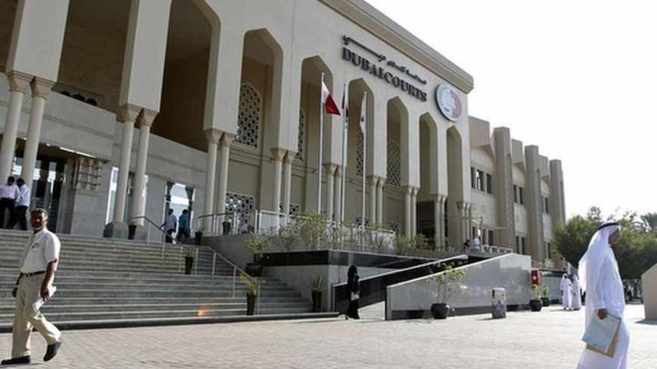 A man walks past the Dubai Courts A man walks past the Dubai Courts November 1, 2012. REUTERS/Jumana ElHeloueh (UNITED ARAB EMIRATES - Tags: CRIME LAW) - RTR39UPY