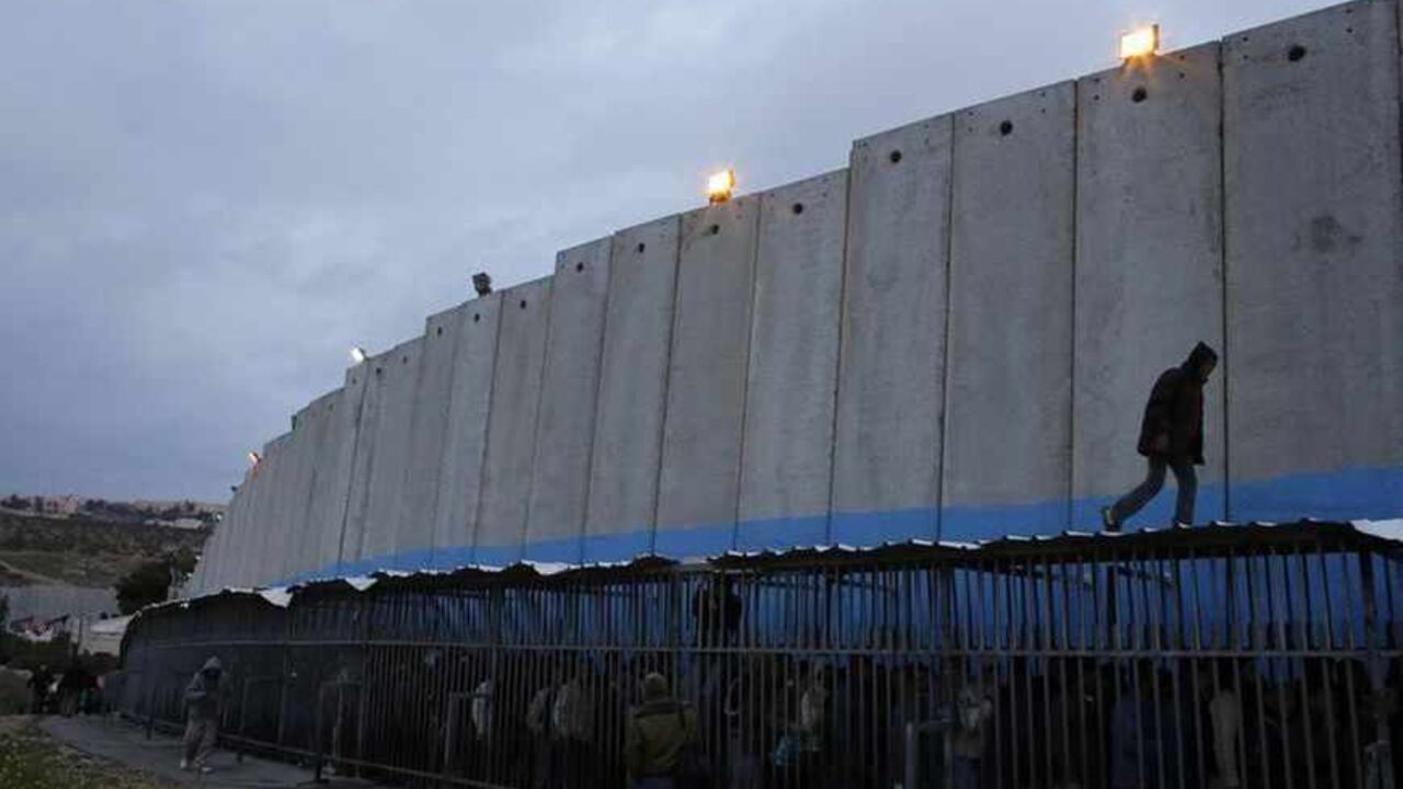 Palestinian labourers queue next to a section of the controversial Israeli barrier as they wait to cross into Jerusalem at an Israeli checkpoint in Bethlehem Palestinian labourers queue next to a section of the controversial Israeli barrier as they wait to cross into Jerusalem at an Israeli checkpoint in the West Bank town of Bethlehem March 18, 2013. U.S. President Barack Obama is due to make his first official visit to Israel and the Palestinian Territories this week, looking to improve ties after sometimes rocky relations with both sides during his first term in office. Israeli settlement expansion lies at the heart of much of the rancour between Israeli Prim