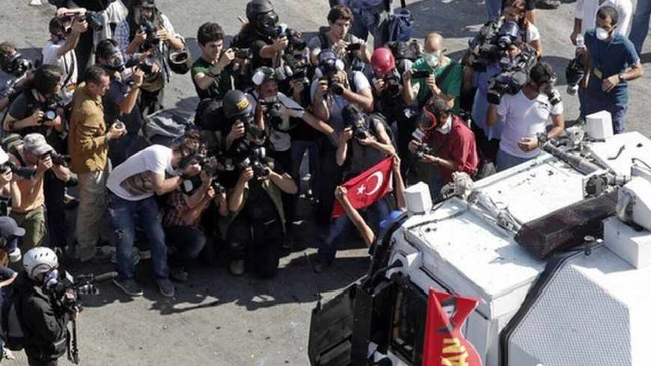 Media takes images of a protester holding a flag in front of a riot police vehicle during a protest at Taksim Square in Istanbul Media takes images of a protester holding a flag in front of a riot police vehicle during a protest at Taksim Square in Istanbul June 11, 2013. Turkish riot police moved on Tuesday into the central Istanbul square at the heart of 10 days of anti-government protests, firing tear gas and water cannon at hundreds of protesters armed with rocks and fireworks. REUTERS/Osman Orsal (TURKEY - Tags: POLITICS CIVIL UNREST) - RTX10K7N