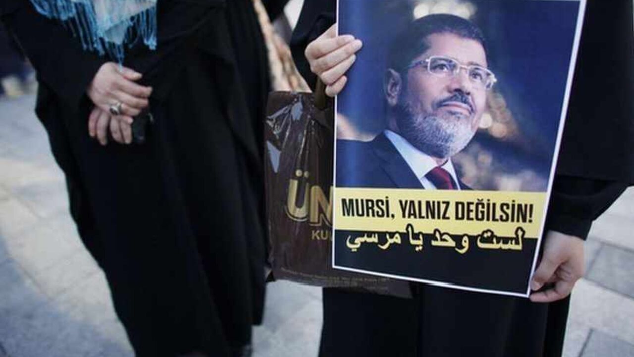 A woman holds a poster of Egypt's President Mohamed Mursi during a pro-Islamist demonstration in Istanbul A woman holds a poster of Egypt's President Mohamed Mursi during a pro-Islamist demonstration in Istanbul July 1, 2013. Pro-Islamist groups held a demonstration in Istanbul in support of Mursi on Tuesday. Egypt's armed forces handed Islamist President Mohamed Mursi a virtual ultimatum to share power on Monday, giving feuding politicians 48 hours to compromise or have the army impose its own road map for the country. The slogan on the poster reads, "Mursi, you are not alone!" REUTERS/Murad Sezer (TURKEY - Ta