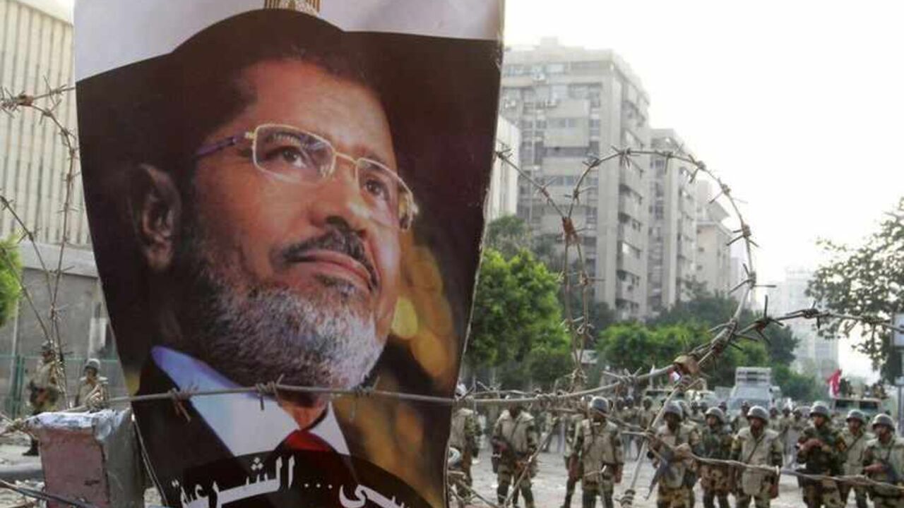 A portrait of deposed Egyptian President Mohamed Mursi is seen on barbed wire outside the Republican Guard headquarters in Cairo A portrait of deposed Egyptian President Mohamed Mursi is seen on barbed wire outside the Republican Guard headquarters in Cairo July 8, 2013. At least 51 people were killed on Monday when demonstrators enraged by the military overthrow of Egypt's elected Islamist president said the army opened fire during morning prayers outside the Cairo barracks where Mursi is believed to be held .REUTERS/Louafi Larbi (EGYPT - Tags: POLITICS CIVIL UNREST MILITARY) - RTX11GWI