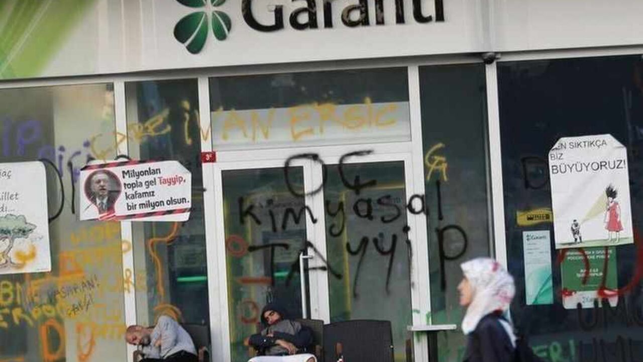 Protesters sleep outside a branch of Garanti Bank at Taksim Square in central Istanbul Protesters sleep outside a branch of Garanti Bank at Taksim Square in central Istanbul June 3, 2013. Turkish protesters clashed with riot police into the early hours of Monday with some setting fire to offices of the ruling AK Party as the fiercest anti-government demonstrations in years entered their fourth day. Turkey's streets were calm in the morning after a night of noisy protests and violence in major cities. The posters read, "A tree died, a nation awoke" (L), "Come with millions Tayyip" (2nd L), "Yo