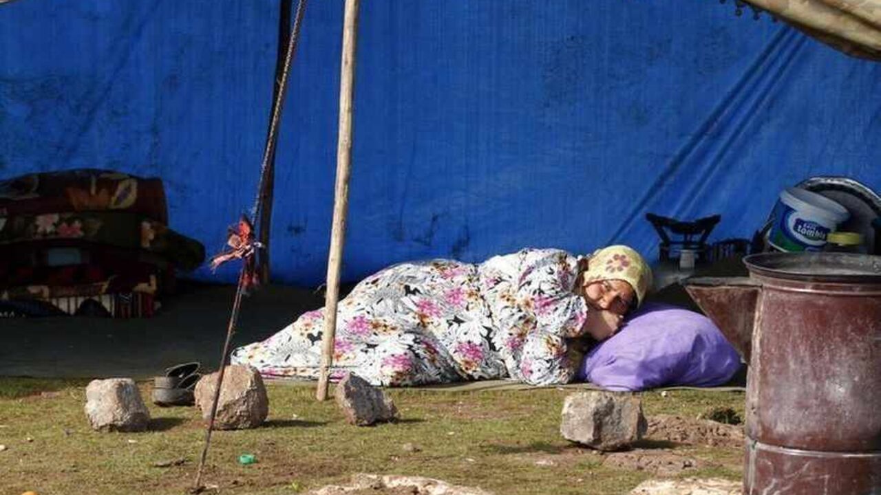 A Syrian refugee woman lies down as she rests in front of her makeshift tent in the town of Viransehir in Sanliurfa province A Syrian refugee woman lies down as she rests in front of her makeshift tent in the town of Viransehir in Sanliurfa province, southeast Turkey, February 10, 2013. Some 50 families, mostly from villages near Syria's Aleppo, prefer to settle in the outskirts of Viransehir instead of refugee camps run by the Turkish government. According to the families, this allows them to work as seasonal agricultural workers. REUTERS/Umit Bektas (TURKEY - Tags: POLITICS SOCIETY CIVIL UNREST BUSINESS EMPLOYMENT) - RTR3DL0G
