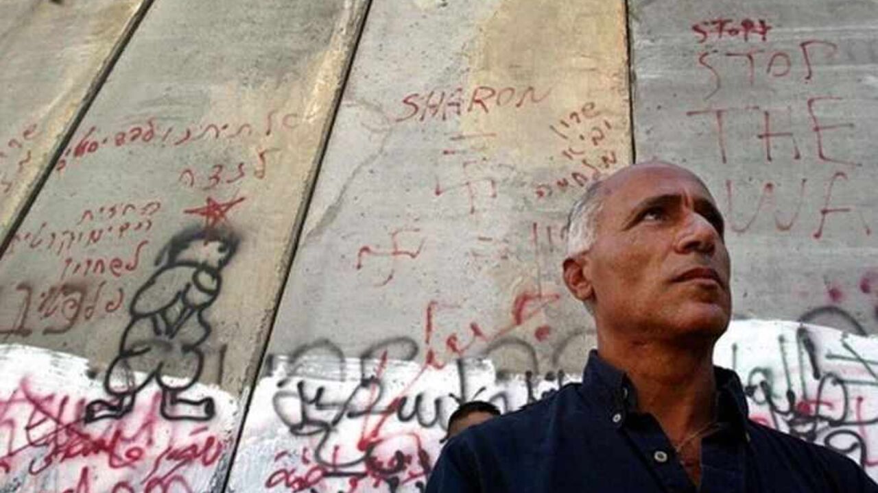 MIDEAST The Israeli nuclear whistleblower Mordechai Vanunu stands in front of separation wall during a protest against controversial Israeli security barrier in East Jerusalem. The Israeli nuclear whistleblower Mordechai Vanunu who was freed from prison in April stands in front of the separation wall during a protest against the controversial Israeli security barrier in East Jerusalem August 27, 2004. The grandson of Mahatma Gandhi told Palestinian protesters at Israel's West Bank barrier on Friday that the wall r