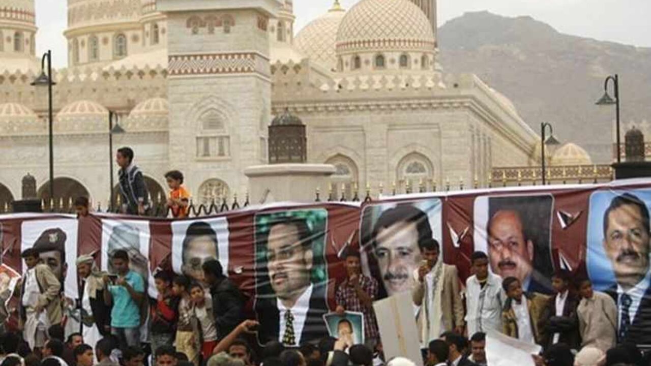 People gather next to posters of former Yemeni officials who were injured along with the country's former President Ali Abdullah Saleh in the June 2011 bomb attack at the Presidential Palace, in Sanaa May 17, 2013. Loyalists to Saleh marked on Friday the second anniversary of the attack. REUTERS/Khaled Abdullah (YEMEN - Tags: POLITICS CIVIL UNREST ANNIVERSARY) - RTXZQIE