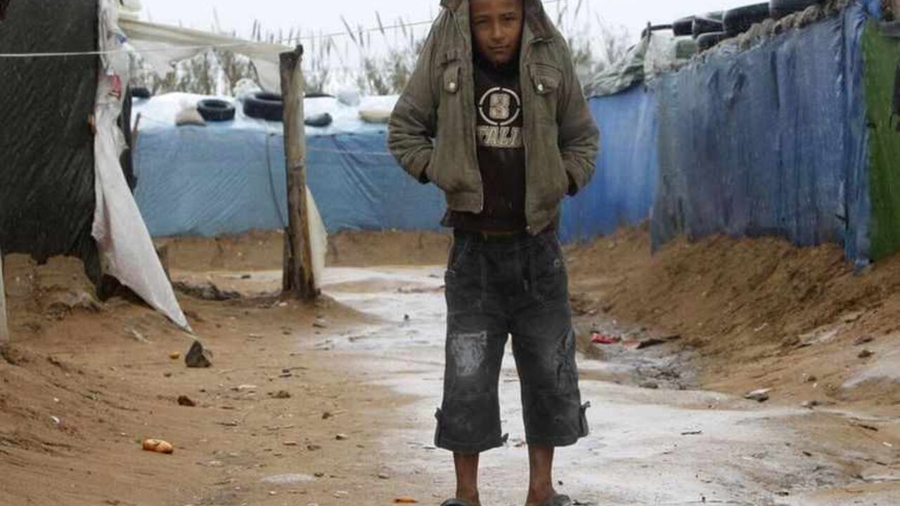 A Syrian refugee boy shields himself from the rain with his jacket at a refugee camp in the city of Tyre A Syrian refugee boy shields himself from the rain with his jacket at a refugee camp in the city of Tyre in southern Lebanon January 31, 2013. Donor countries have pledged more than $1.5 billion to aid Syrians stricken by civil war, U.N. Secretary-General Ban Ki-moon said on Wednesday after warning that the conflict had wrought a catastrophic humanitarian crisis. REUTERS/Ali Hashisho (LEBANON - Tags: POLITICS CIVIL UNREST TPX IMAGES OF THE DAY) - RTR3D6R0