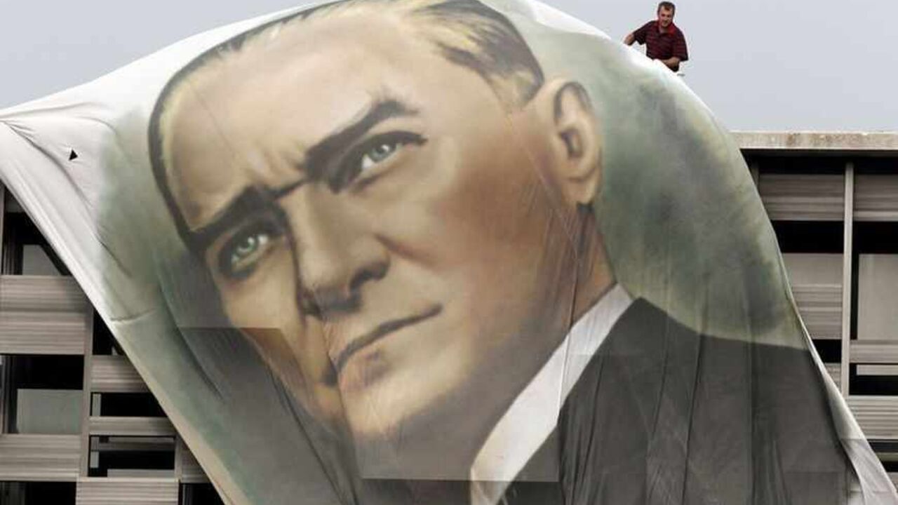 A worker fixes a giant portrait of Mustafa Kemal Ataturk at the top of the Ataturk Cultural Center in Istanbul's Taksim Square A worker fixes a giant portrait of Mustafa Kemal Ataturk at the top of the Ataturk Cultural Center in Istanbul's Taksim Square June 28, 2013. REUTERS/Osman Orsal (TURKEY - Tags: POLITICS CIVIL UNREST TPX IMAGES OF THE DAY) - RTX114YL