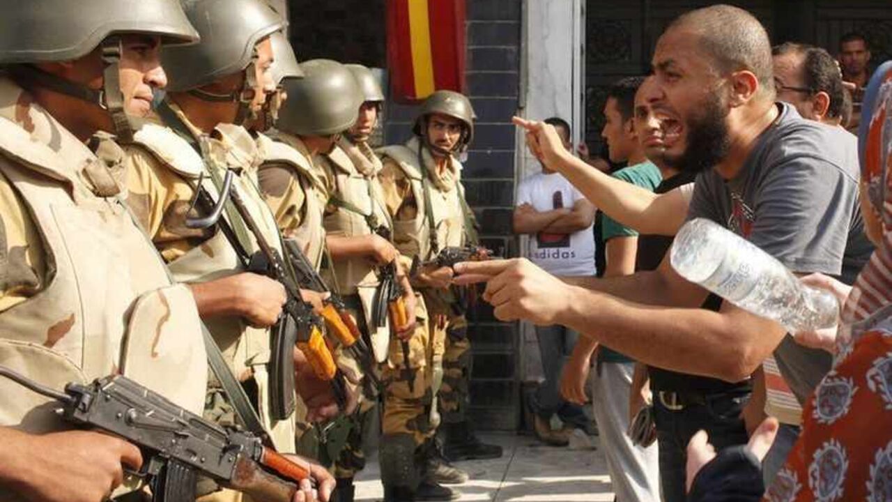 Supporters of ousted Egyptian President Mohamed Mursi argue with riot police and army personnel during clashes near Rabaa Adawiya square Supporters of ousted Egyptian President Mohamed Mursi argue with riot police and army personnel during clashes near Rabaa Adawiya square in Cairo August 14, 2013. Egypt is in turmoil after security forces moved in to clear the protest camps of thousands of supporters of deposed Islamist president Mohamed Mursi on Wednesday, and violence spread around the country. Protesters clashed with police and troops who used bulldozers, teargas and live ammunition to clear two Cairo sit-ins. Egypt's health ministry say