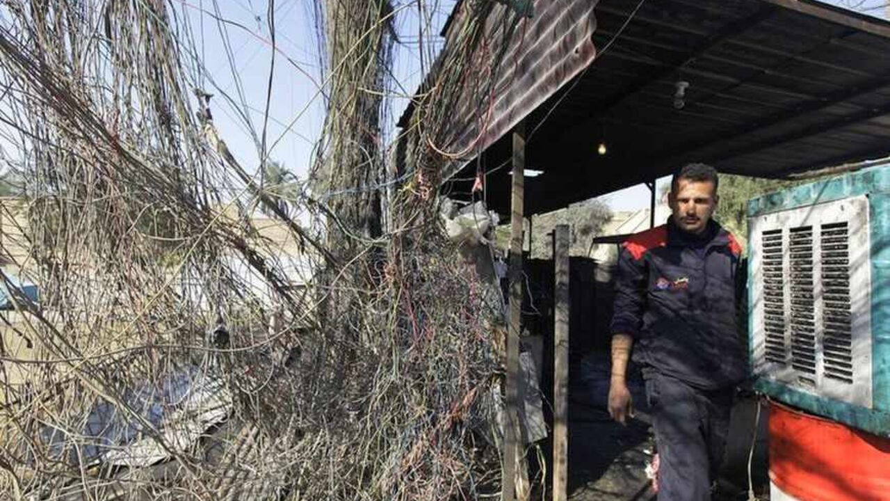 To match Feature IRAQ-ELECTRICITY/ An electrician walks past wires connected to a local generator in Baghdad January 23, 2011. Iraq is slowly getting back on its feet after decades of war and economic sanctions, but a chronic power shortage is hobbling the development of local industry just when it is needed most. An unemployment rate that some officials say runs at 30 percent represents not just an economic challenge but also provides muscle for a lingering insurgency as the sectarian warfare unleashed after the 2003 U.S.-led invasion fades