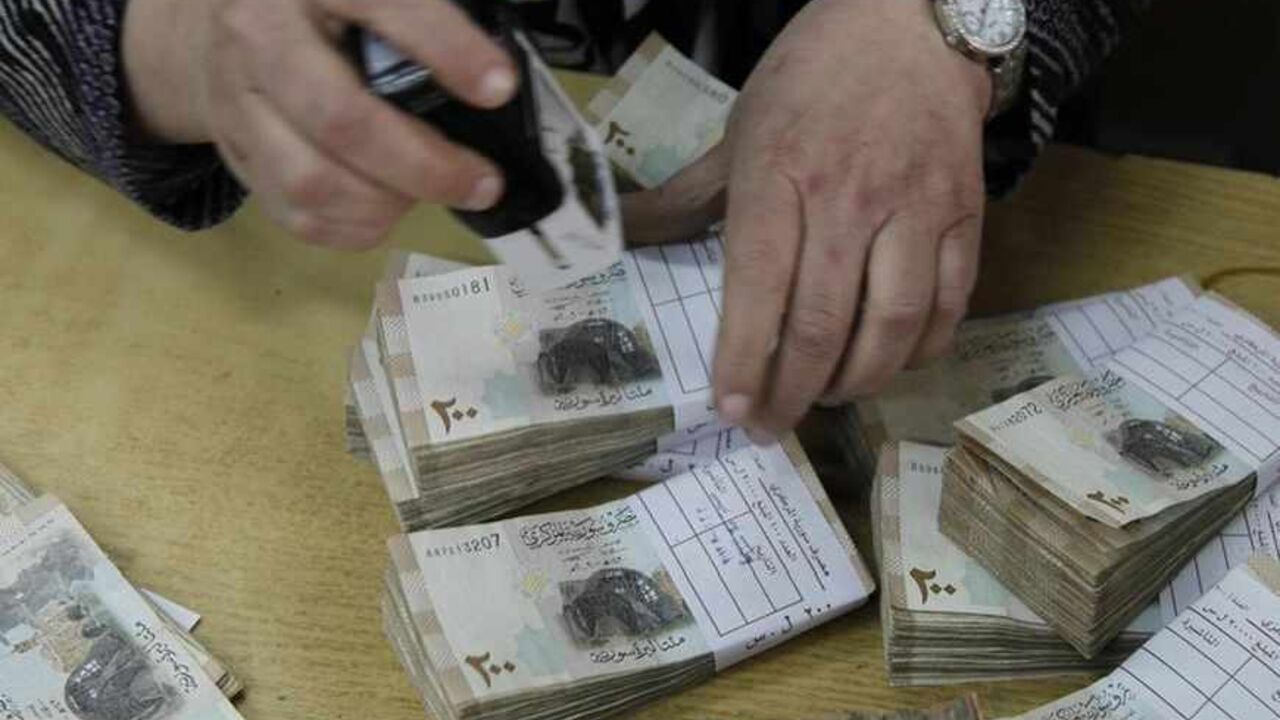 An employee stamps stacks of Syrian pound notes at the Syrian central bank in Damascus An employee stamps stacks of Syrian pound notes at the Syrian central bank in Damascus April 23, 2013. Picture taken April 23, 2013. To match SYRIA-CURRENCY/ REUTERS/Khaled al-Hariri (SYRIA - Tags: POLITICS CONFLICT BUSINESS) - RTXYYC3