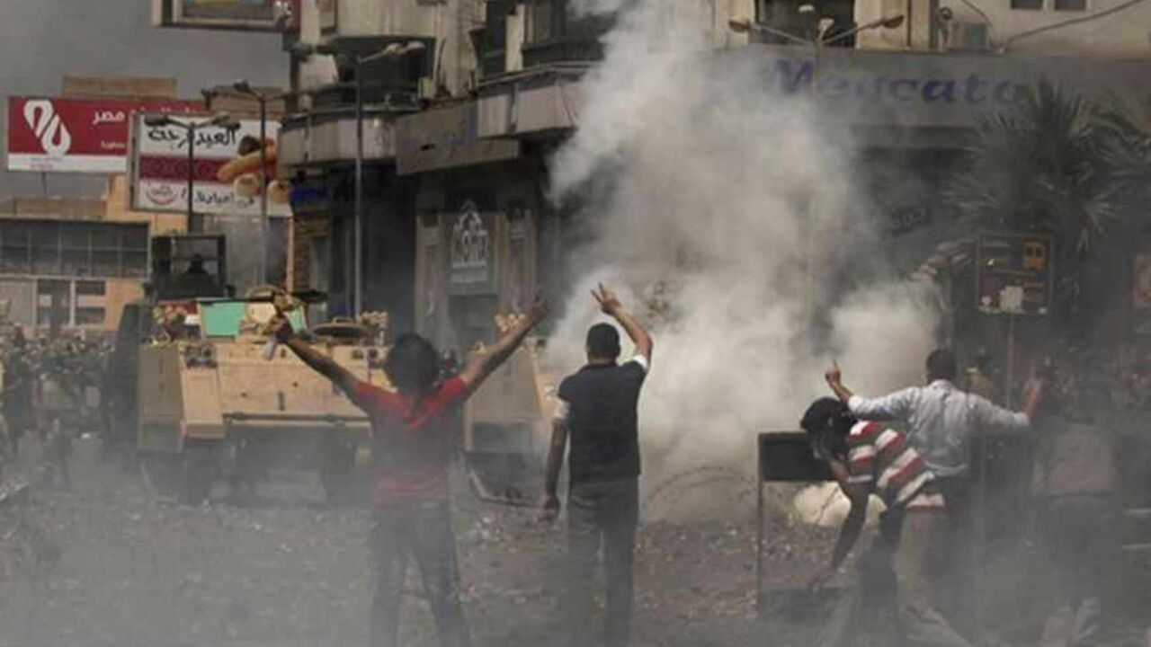 EGYPT/ Supporters of ousted Egyptian President Mohamed Mursi throw stones at riot police and army personnel during clashes near Rabaa Adawiya square in Cairo August 14, 2013. Egypt is in turmoil after security forces moved in to clear the protest camps of thousands of supporters of deposed Islamist president Mohamed Mursi on Wednesday, and violence spread around the country. Protesters clashed with police and troops who used bulldozers, teargas and live ammunition to clear two Cairo sit-ins. Egypt's health ministr