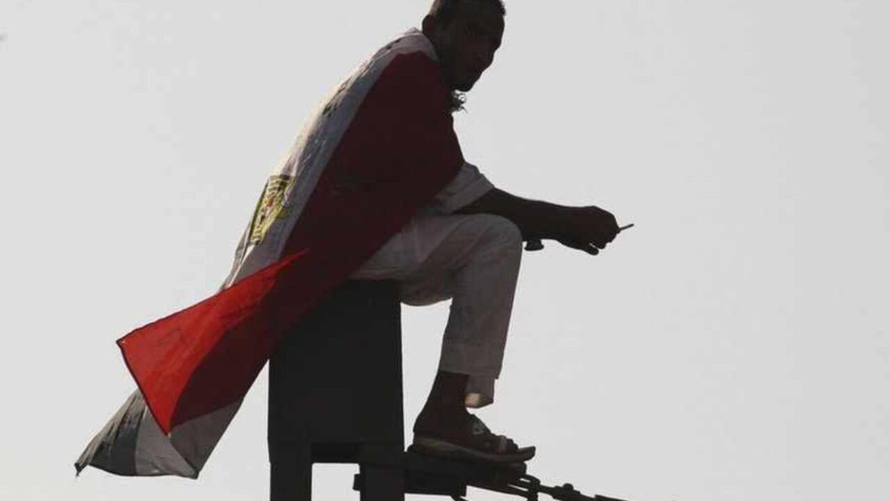 A supporter of Muslim Brotherhood and ousted Egyptian President Mursi wrapped in an Egyptian flag sits on top of power pole during a protest in Cairo A supporter of Muslim Brotherhood and ousted Egyptian President Mohamed Mursi wrapped in an Egyptian flag sits on top of power pole during a protest in Cairo August 23, 2013. Mass protests called by Egypt's Muslim Brotherhood mostly failed to materialise on Friday as the movement reeled from a bloody army crackdown on followers of Mursi. REUTERS/Muhammad Hamed (EGYPT - Tags: POLITICS CIVIL UNREST) - RTX12UJ2