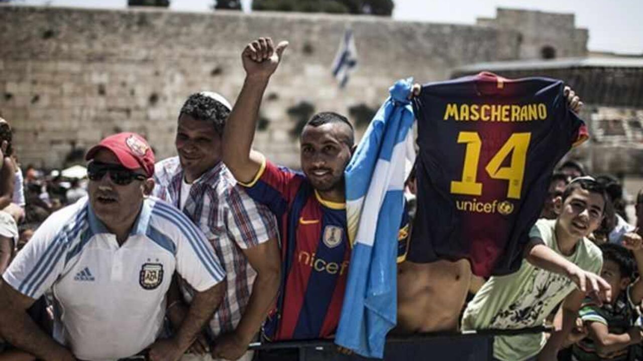 SOCCER-BARCELONA/ISRAEL Fans of FC Barcelona cheer as the team leaves the Western Wall, Judaism's holiest prayer site, in Jerusalem's Old City August 4, 2013. The Spanish league champions are making a brief stopover in Israel and the Palestinian territories en-route to a pre-season tour of Asia. REUTERS/Oliver Weiken/Pool (JERUSALEM - Tags: POLITICS SPORT RELIGION SOCCER) - RTX12A38