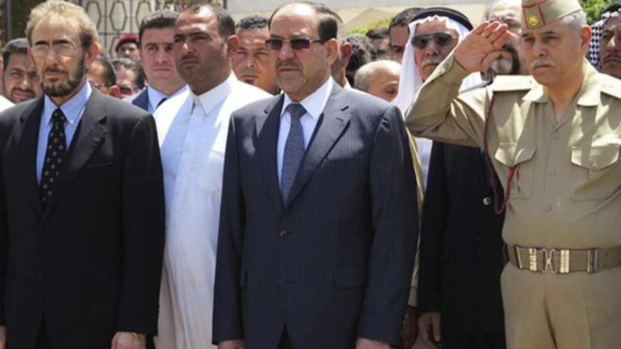 IRAQ-VIOLENCE/ Iraq's Prime Minister Nuri al-Maliki (C) and acting Defence Minister Saadoun al-Dulaimi (L) attend a funeral ceremony for soldiers killed by militants, in Baghdad April 28, 2013. Militants shot dead five Iraqi soldiers in the Sunni Muslim stronghold province of Anbar on Saturday and protesters said they were forming an "army" after four days of unrest that raised fears of a return to widespread sectarian civil conflict. REUTERS/Stringer (IRAQ - Tags: POLITICS MILITARY CIVIL UNREST) - RTXZ2Y6