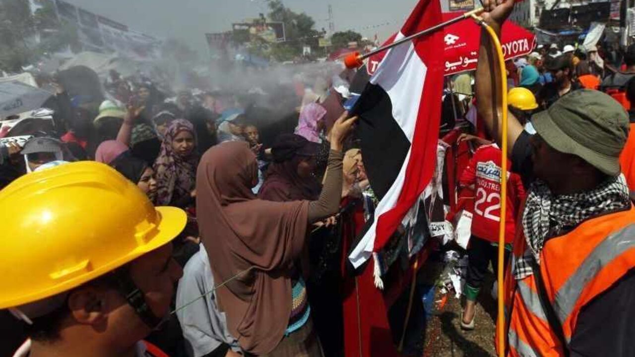 EGYPT-PROTESTS/ A man sprays water on supporters of deposed Egyptian President Mohamed Mursi, as they shout slogans during a protest at the Rabaa Adawiya square where they are camping, in Cairo August 2, 2013. Tens of thousands of supporters of Mursi marched through Cairo on Friday, demanding Mursi's reinstatement amidst a looming threat that Egyptian authorities will clear out two pro-Mursi sit-ins with force. REUTERS/Mohamed Abd El Ghany (EGYPT - Tags: POLITICS CIVIL UNREST) - RTX128JA