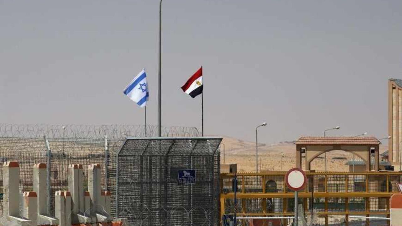 EGYPT-PROTESTS/ An Israeli flag (L) flutters next to an Egyptian one at the Nitzana crossing, along Israel's border with Egypt's Sinai desert, as seen from the Israeli side August 20, 2013. Egypt began three days of official mourning for 25 policemen killed on Monday by suspected Islamist militants in the Sinai near the desert border with Israel. REUTERS/Ronen Zvulun (ISRAEL - Tags: POLITICS) - RTX12RGM