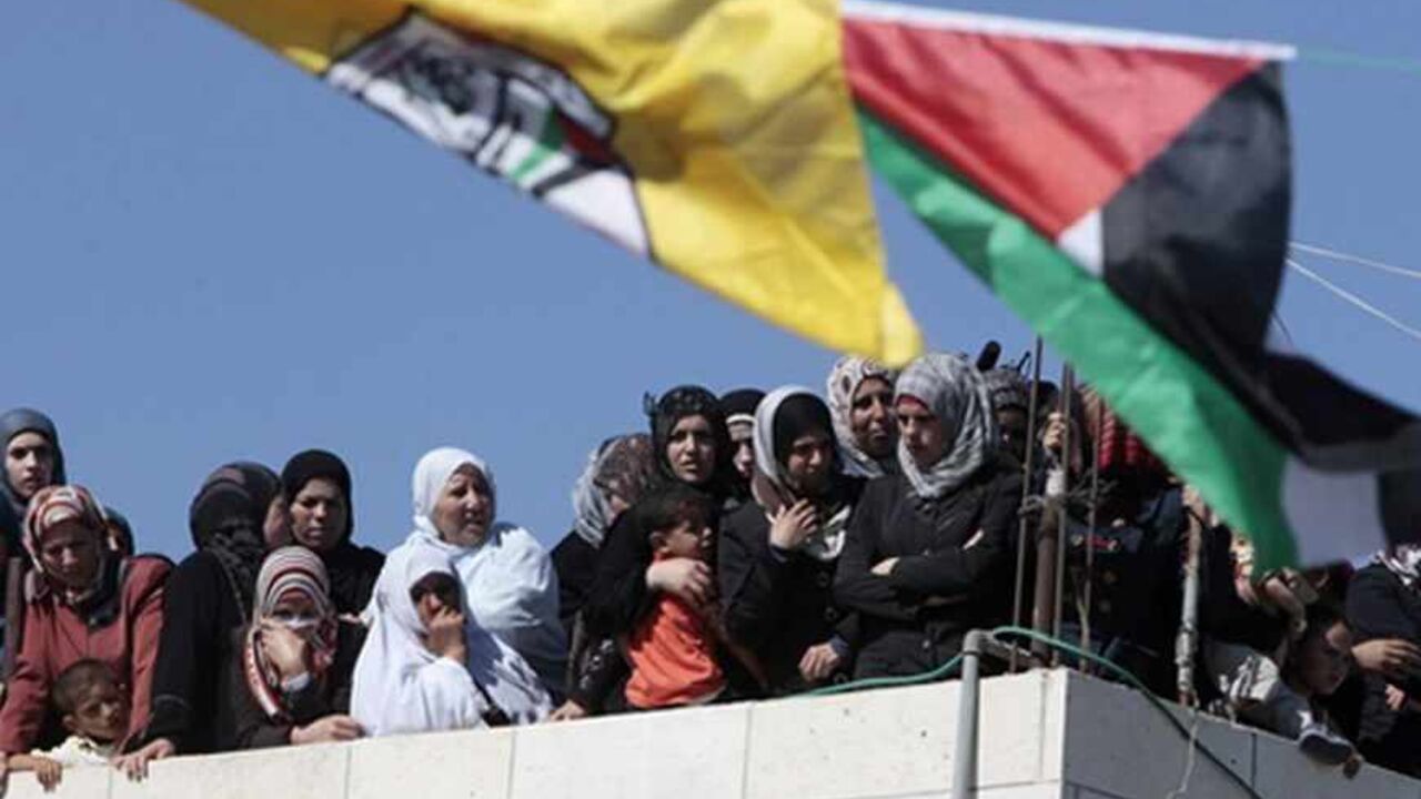 PALESTINIANS-ISRAEL/VIOLENCE Palestinian women watch the funeral of Moataz Sharawneh in the West Bank village of Dura, near Hebron July 2, 2013. Israeli soldiers shot dead Sharawneh during a confrontation in the occupied West Bank on Tuesday, Palestinian officials said. An Israeli military spokeswoman said Palestinians threw rocks at soldiers who were on routine duties in Dura. REUTERS/Ammar Awad (WEST BANK - Tags: POLITICS CIVIL UNREST) - RTX11A6N