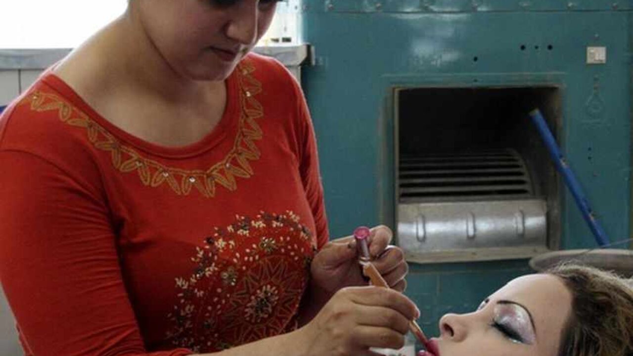 A woman applies lipstick at a beauty parlour in Baghdad A woman applies lipstick at a beauty parlour in Baghdad September 21, 2011. As Iraq's violence ebbs and Baghdad life stabilizes, hair salons, gyms or beauty centres are starting to flourish again in the capital, bringing the city's women the touch of glamour they lost during the country's bloody sectarian strife and the economic sanctions in the 1990s. Picture taken September 21, 2011. REUTERS/Stringer (IRAQ - Tags: SOCIETY) - RTR2SK4Q