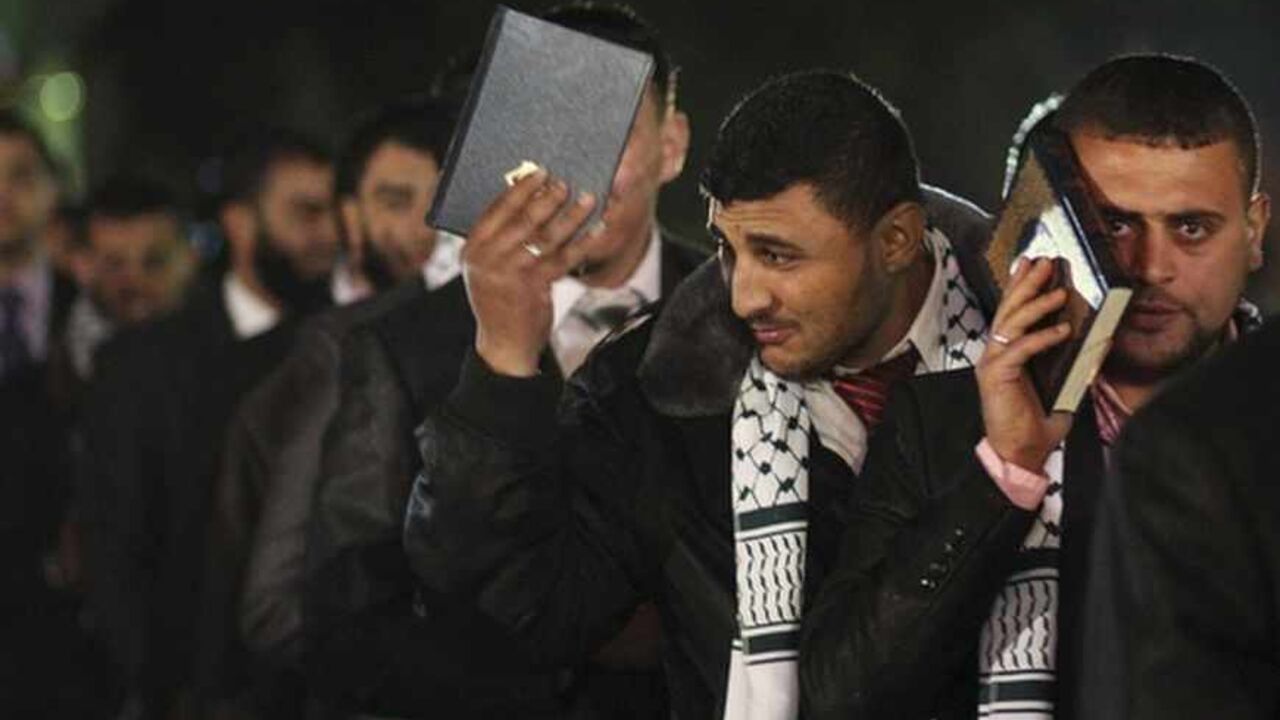 Palestinian grooms hold copies of the Koran during a mass wedding for 500 couples in Gaza City Palestinian grooms hold copies of the Koran during a mass wedding for 500 couples, funded by a local charitable organisation and in co-ordination with Hamas, in Gaza City March 8, 2012. REUTERS/ Suhaib Salem (GAZA - Tags: SOCIETY) - RTR2Z1WC