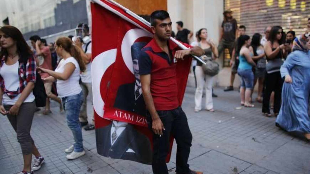A street vendor sells Turkish flags bearing images of Mustafa Kemal Ataturk as demonstrators gather for an anti-government protest in Istanbul A street vendor sells Turkish flags bearing images of Mustafa Kemal Ataturk, the first president of Turkey, as demonstrators gather for an anti-government protest on the main Istiklal Street in central Istanbul August 3, 2013. REUTERS/Murad Sezer (TURKEY - Tags: POLITICS CIVIL UNREST) - RTX129LP
