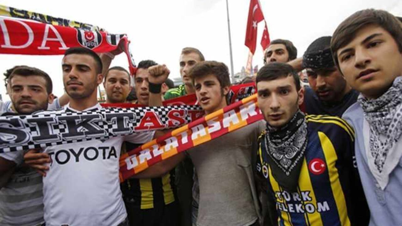 TURKEY-PROTESTS/SOCCER Fans of Besiktas (Black-White), Galatasaray (Yellow-Red) and Fenerbahce (Yellow-Blue) pose during an anti-government protest at Taksim Square in central Istanbul June 2, 2013. Days of anti-government protest in Turkey have achieved one feat that has eluded the authorities for years: uniting the fiercely rival and sometimes violent supporters of Istanbul's "Big Three" football clubs. Besiktas, Galatasaray and Fenerbahce fans have come together in new-found solidarity during five days of demonstrations agains