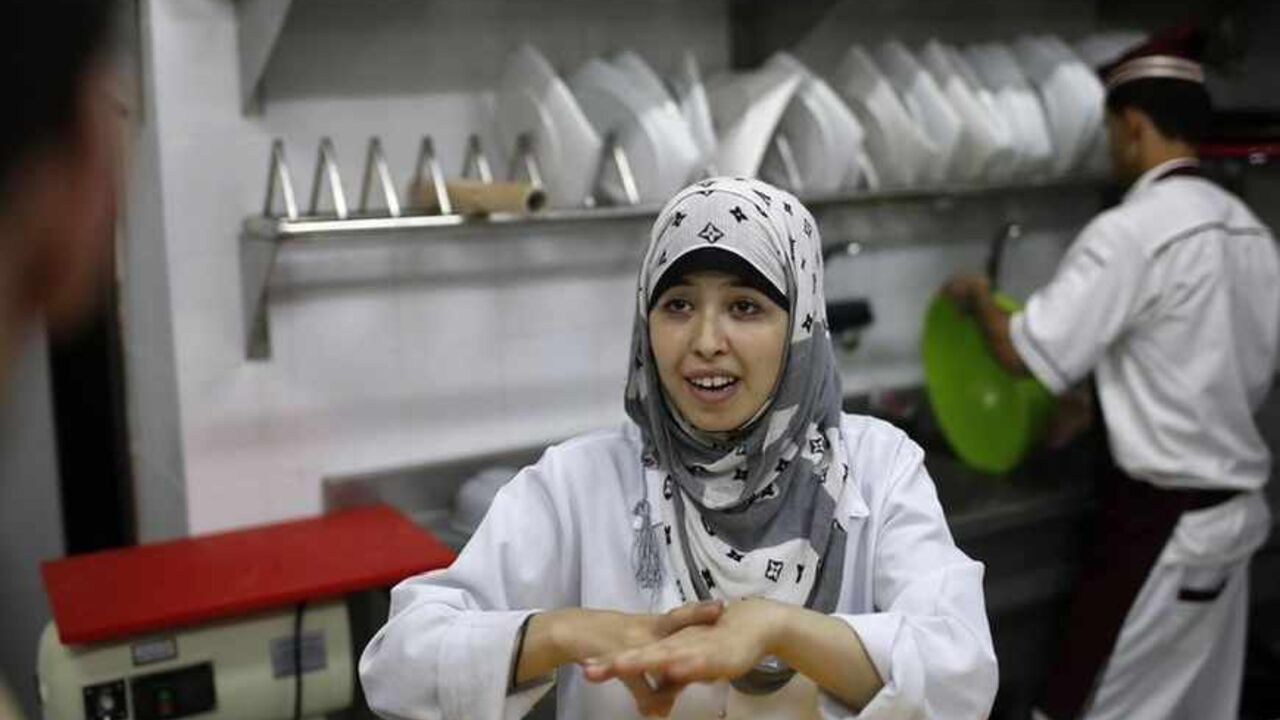 A hearing impaired employee uses sign language to communicate with a co-worker in the kitchen of a restaurant in Gaza A hearing impaired employee uses sign language to communicate with a co-worker in the kitchen of Atfaluna restaurant in Gaza City October 17, 2012. The restaurant run and staffed by deaf people opened for business in the Gaza Strip on Tuesday, helped by Palestinians seeking to build a more inclusive society where people with disabilities can realise their full potential. Picture taken October 17, 2012. REUTERS/Suhaib Salem (GAZA - Tags: FOOD SOCIETY) - RTR39A69