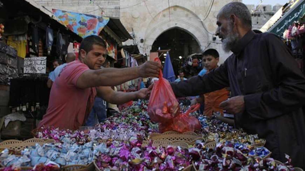 PALESTINIANS-ISRAEL/ Palestinians buy sweets in Jerusalem's Old City ahead of the Muslim holiday of Eid al-Fitr, which marks the end of the holy month of Ramadan, August 7, 2013. REUTERS/Ammar Awad (JERUSALEM - Tags: RELIGION FOOD) - RTX12D0X