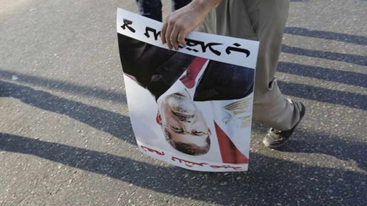 EGYPT-PROTESTS/ A supporter of deposed Egyptian President Mohamed Mursi holds a poster of him during a protest along Zahara street in Cairo August 18, 2013. Egypt's army-backed rulers met on Sunday to discuss their bloody confrontation with deposed President Mohamed Mursi's Muslim Brotherhood amid contrasting proposals for compromise and a fight to the death. REUTERS/Youssef Boudlal (EGYPT - Tags: POLITICS CIVIL UNREST) - RTX12Q2U