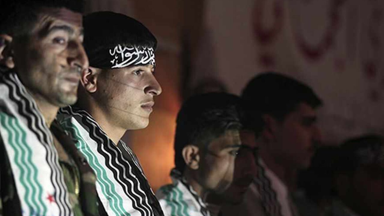 SYRIA-CRISIS Nader, a 20-year-old fighter of the first batch of the Al-Tawhid Brigade, stands beside other grooms during his wedding ceremony in Aleppo's countryside city of Al-Bab March 15, 2013. A mass wedding took place for fourteen members of the first batch of the Al-Tawhid Brigade, which operates under the Free Syrian Army, in Al-Bab. Picture taken March 15, 2013. REUTERS/Giath Taha (SYRIA - Tags: CIVIL UNREST CONFLICT SOCIETY) - RTR3F2PX