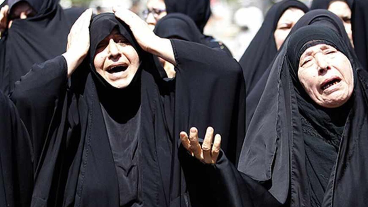 Shi'ite women react during a mass funeral for victims of Wednesday's bomb attacks on a Shi'ite mosque in Baghdad September 12, 2013. The co-ordinated car and suicide bomb attack on the Shi'ite mosque in the Iraqi capital killed at least 33 people on Wednesday evening, police and medical sources said. REUTERS/Thaier Al-Sudani (IRAQ - Tags: POLITICS CIVIL UNREST) - RTX13IL5