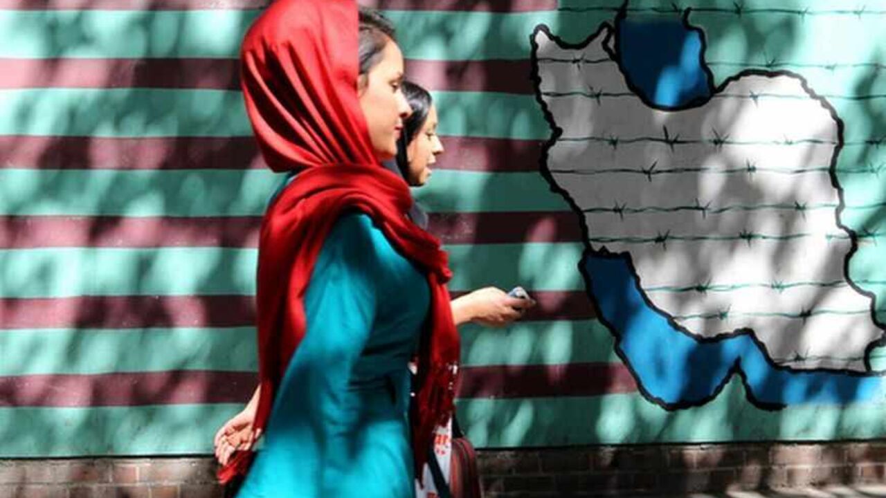 IRAN-US-DIPLOMACY-NUCLEAR Iranian women walk past a mural showing an interpretation of the Statue of Liberty bearing the face of a skull on the wall of the former US embassy in Tehran on September 25, 2013. Leaders from Iran and the United States have not met since the 1979 Islamic Revolution brought often open hostility to their contacts, particularly over Iran's contested nuclear program. AFP PHOTO/ATTA KENARE (Photo credit should read ATTA KENARE/AFP/Getty Images)