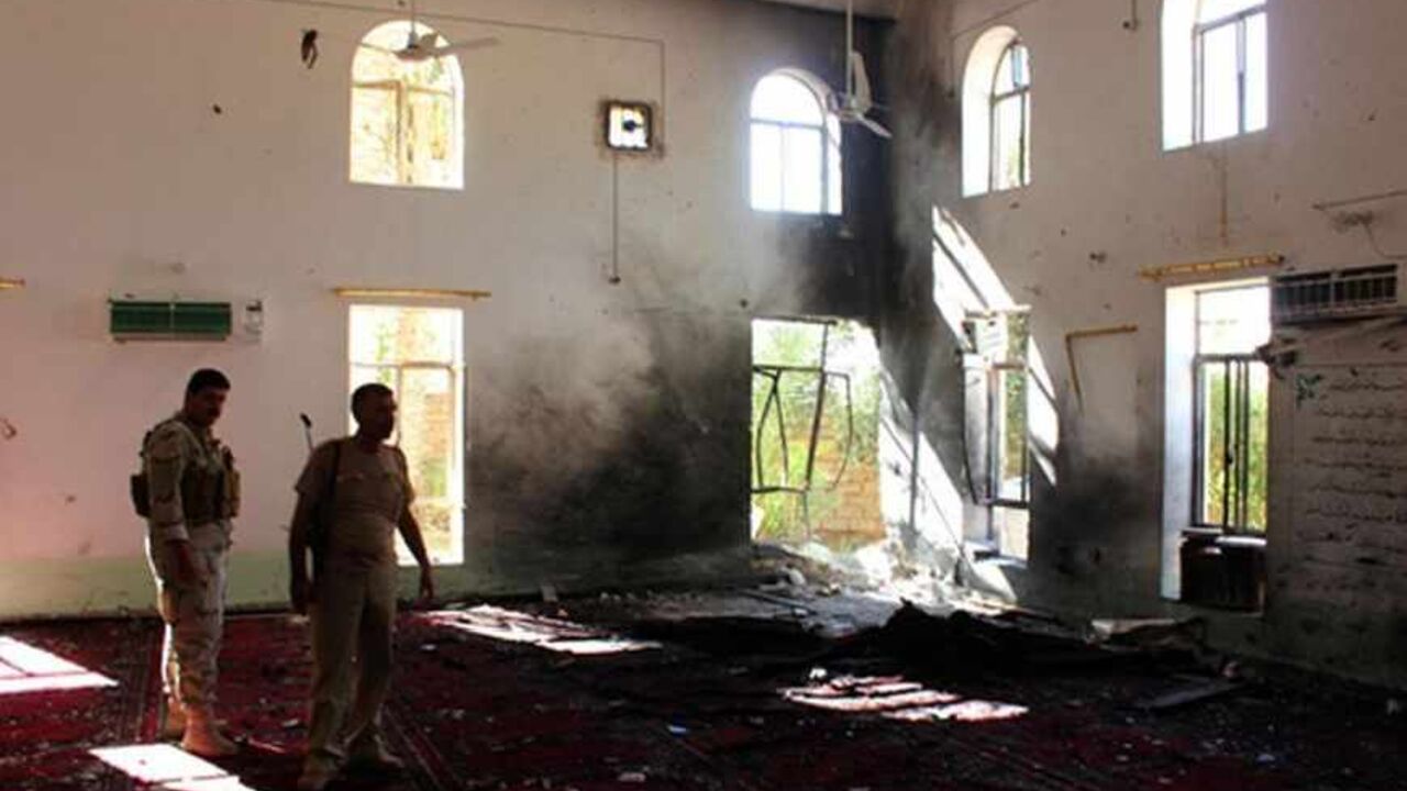 IRAQ-VIOLENCE/ Iraqi security forces stand inside a Sunni mosque at the site of a suicide bomber attack in the town of Wajihiya in the ethnically and religiously diverse province of Diyala, July 20, 2013. A suicide bomber blew himself up inside a Sunni mosque in central Iraq, killing at least 20 people in the middle of a sermon on Friday. REUTERS Mohammed Adnan (IRAQ - Tags: CIVIL UNREST POLITICS) - RTX11SM4
