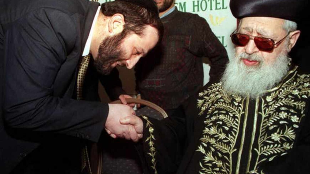 ARYEH DERI WITH RABBI OVADIA YOSEF IN JERUSALEM. Aryeh Deri, (L), a political kingmaker and head of the ultra-Orthodox Shas party, kisses the hand of the party's spiritual leader, Rabbi Ovadia Yosef, at a women's conference March 16, a day before an Israeli court is due to rule in his fraud and bribery trial. Israeli Police are preparing for large protests by Shas supporters if the verdict goes against Deri, who has been on trial since 1993 on charges he illegally channelled government funds to Shas-affiliated organisations and pocketed some of the money